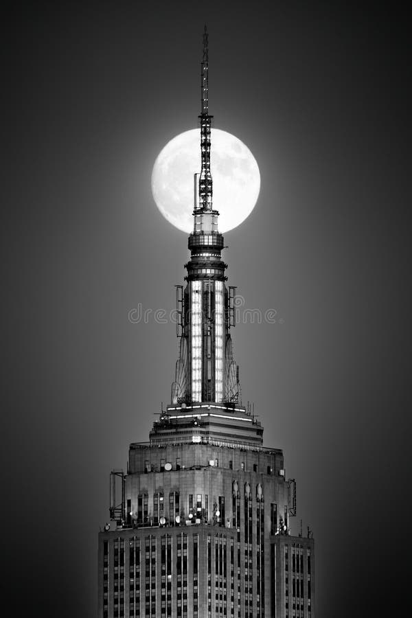 De volle maan neemt en richt zich op de bovenkant van het Empire State Building toe royalty-vrije stock foto's De volle maan neemt en richt zich op de bovenkant van het Empire State Building toe royalty-vrije stock foto's