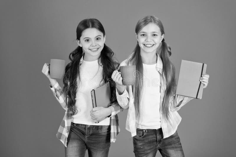 De vrienden besteden de boeken van de vrije tijdslezing Hebbend onderbreking ontspan Het drinken van thee terwijl het lezen van b stock foto De vrienden besteden de boeken van de vrije tijdslezing Hebbend onderbreking ontspan Het drinken van thee terwijl het lezen van b stock foto