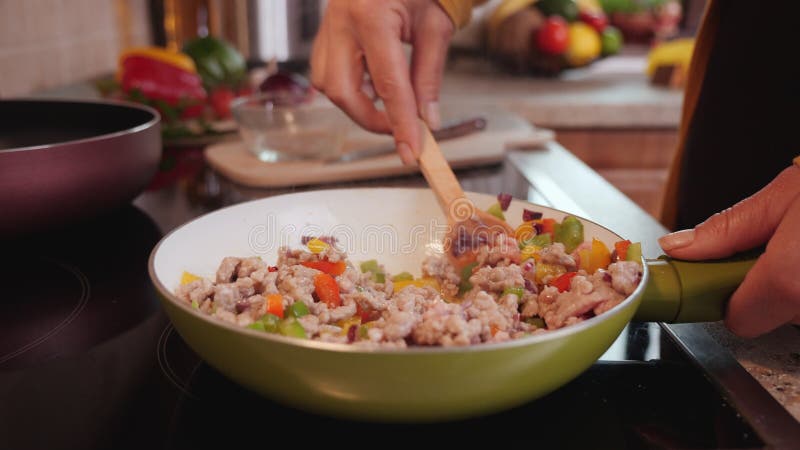 De vrouw bereidt een heerlijk maaltijd voor in het bakken van pan homemade voedsel gemaakt van plantaardig mengsel en gemalen vlee