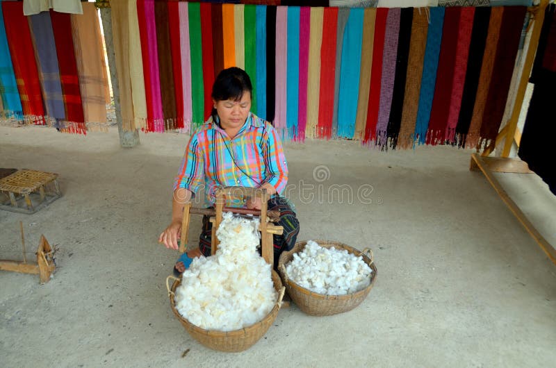 LUANG PRABANG LAOS MARCH 29: Unidentified woman prepare cotton fibers on march 29 2013 in Luang Prabang Laos. People of the Phu-Tai ethnic group have a long standing tradition of cotton production. LUANG PRABANG LAOS MARCH 29: Unidentified woman prepare cotton fibers on march 29 2013 in Luang Prabang Laos. People of the Phu-Tai ethnic group have a long standing tradition of cotton production.