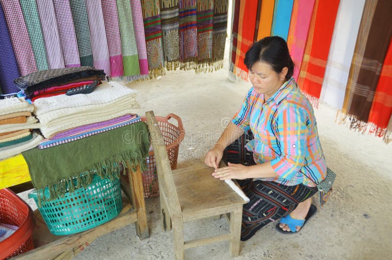 LUANG PRABANG LAOS MARCH 29: Unidentified woman prepare cotton fibers on march 29 2013 in Luang Prabang Laos. People of the Phu-Tai ethnic group have a long standing tradition of cotton production. LUANG PRABANG LAOS MARCH 29: Unidentified woman prepare cotton fibers on march 29 2013 in Luang Prabang Laos. People of the Phu-Tai ethnic group have a long standing tradition of cotton production.