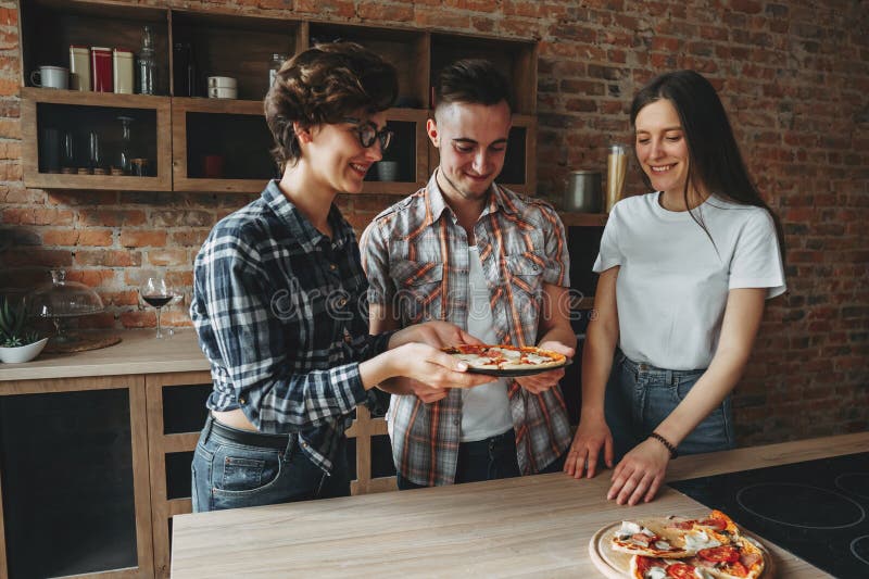 De vrouw brengt verse eigengemaakte pizza aan haar vrienden royalty-vrije stock foto's De vrouw brengt verse eigengemaakte pizza aan haar vrienden royalty-vrije stock foto's