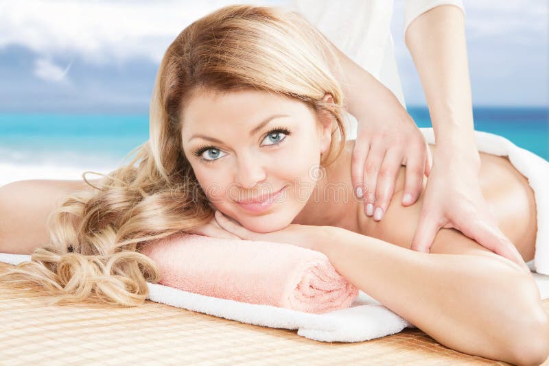 De vrouw die van de blonde een professionele massage op het strand hebben royalty-vrije stock afbeeldingen De vrouw die van de blonde een professionele massage op het strand hebben royalty-vrije stock afbeeldingen