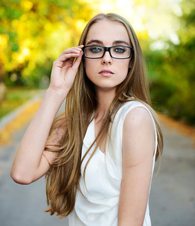 De vrouw die van de blonde oogglazen en witte blouse draagt royalty-vrije stock foto De vrouw die van de blonde oogglazen en witte blouse draagt royalty-vrije stock foto