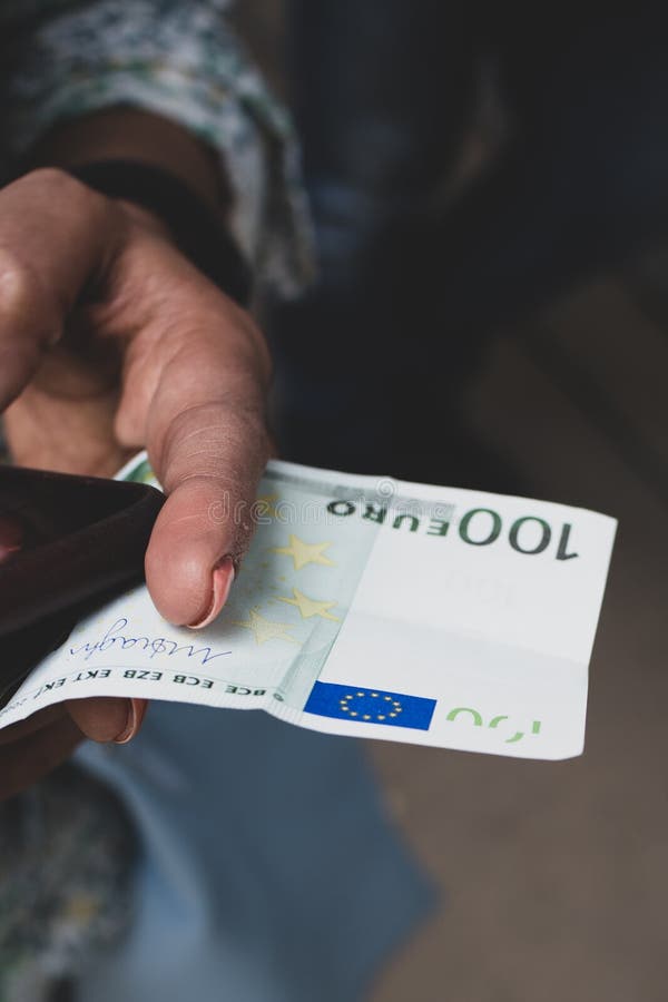 De vrouw houdt een nota â ‚¬100 tussen haar vingers stock afbeeldingen De vrouw houdt een nota â ‚¬100 tussen haar vingers stock afbeeldingen