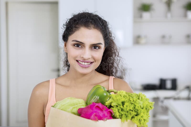 De vrouw houdt het winkelen zak met groenten stock afbeeldingen De vrouw houdt het winkelen zak met groenten stock afbeeldingen