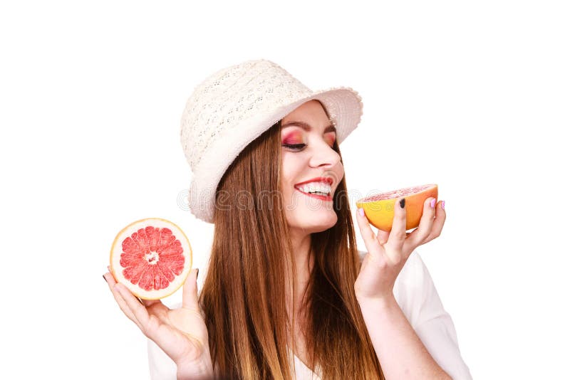 De vrouw houdt twee halfs van grapefruitcitrusvruchten in handen stock afbeeldingen De vrouw houdt twee halfs van grapefruitcitrusvruchten in handen stock afbeeldingen