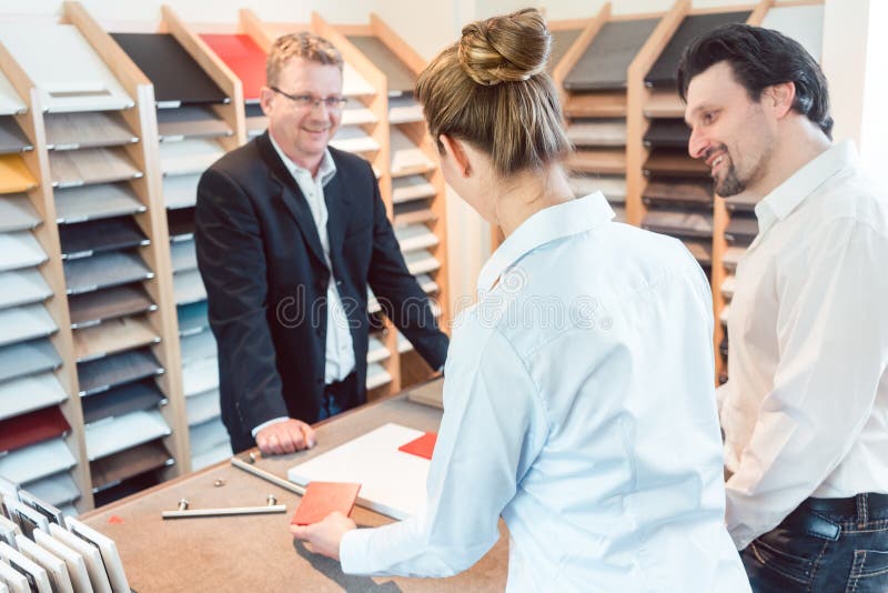 De vrouw, de man, en de deskundige die details van nieuwe keuken bespreken eindigen stock fotografie De vrouw, de man, en de deskundige die details van nieuwe keuken bespreken eindigen stock fotografie
