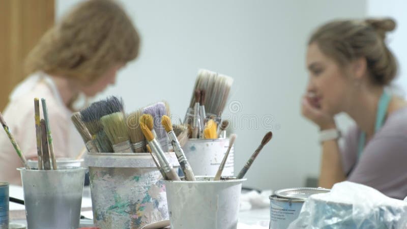 De vrouw in de workshop werkt aan houten raad, die een effect van antiquiteit creëren