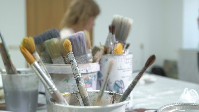 De vrouw in de workshop werkt aan houten raad, die een effect van antiquiteit creëren