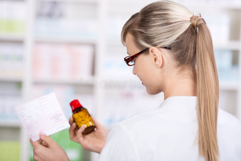 De vrouwelijke apotheker houdt voorschrift en geneeskunde stock foto's De vrouwelijke apotheker houdt voorschrift en geneeskunde stock foto's