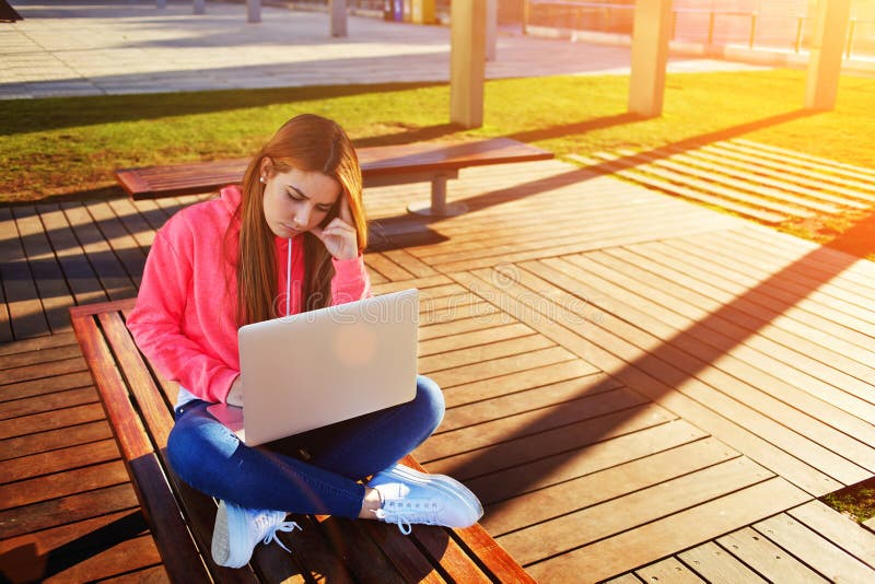 De vrouwelijke die student van het blondehaar en bezige gebruikende laptop computer bij campus wordt geconcentreerd royalty-vrije stock foto's De vrouwelijke die student van het blondehaar en bezige gebruikende laptop computer bij campus wordt geconcentreerd royalty-vrije stock foto's