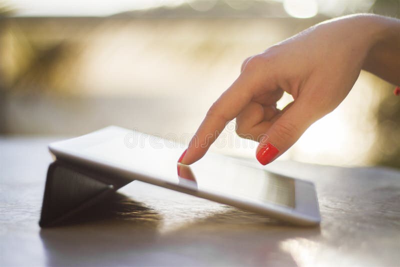 De vrouwelijke hand klikt op een digitale tablet stock foto De vrouwelijke hand klikt op een digitale tablet stock foto