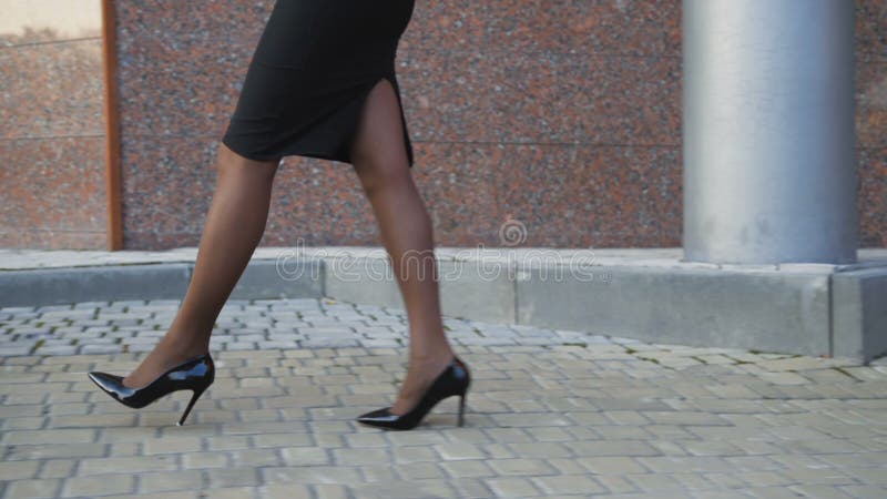 De vrouwelijke sexy benen in legging loopt in de schoenen met lange hielen 4K