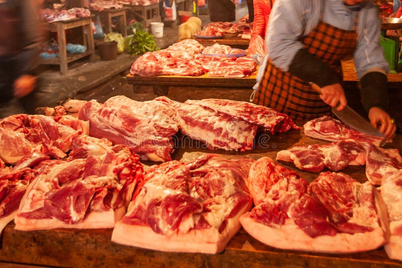 De vrouwelijke slager die het vlees snijden in reepjes bij slachterij tegen, lokale butcher’s winkelt bij Sapa-Markt, Sa-Pa, Vi stock fotografie De vrouwelijke slager die het vlees snijden in reepjes bij slachterij tegen, lokale butcher’s winkelt bij Sapa-Markt, Sa-Pa, Vi stock fotografie