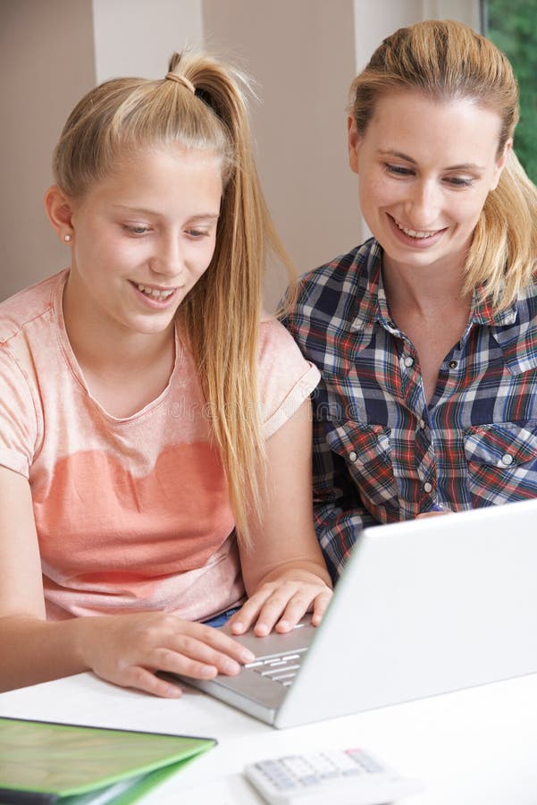 De vrouwelijke Studies die van Helping Girl With van de Huisprivé-leraar Laptop met behulp van stock foto's De vrouwelijke Studies die van Helping Girl With van de Huisprivé-leraar Laptop met behulp van stock foto's