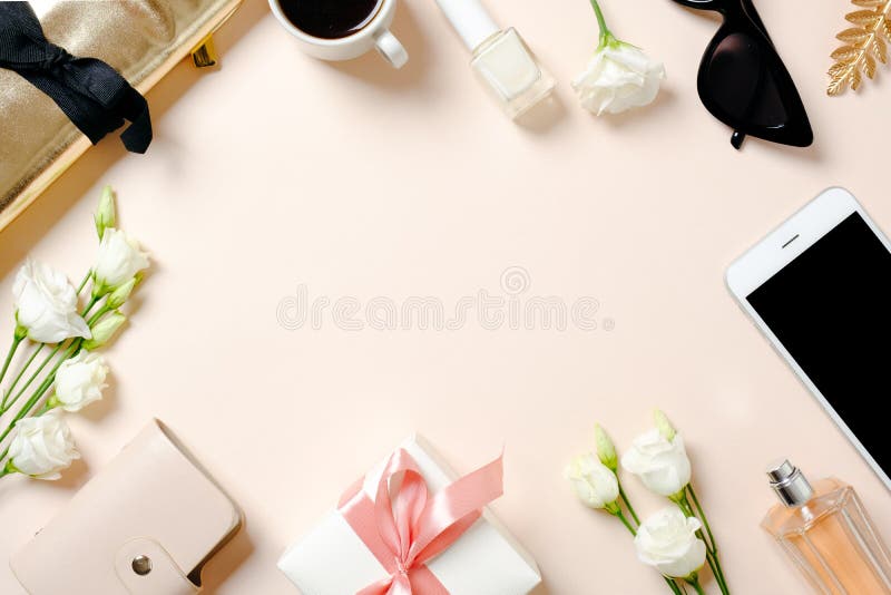 Female workspace with smartphone, roses flowers, golden accessories, gift box, glasses, coffee cup. Flat lay women`s office desk. Top view feminine background. Female workspace with smartphone, roses flowers, golden accessories, gift box, glasses, coffee cup. Flat lay women`s office desk. Top view feminine background