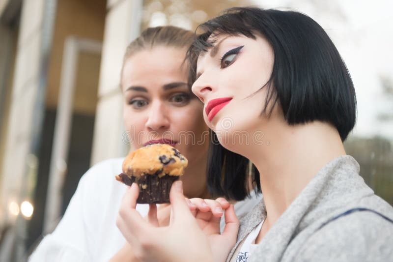 De vrouwen bekijken cupcake in Parijs, Frankrijk royalty-vrije stock fotografie De vrouwen bekijken cupcake in Parijs, Frankrijk royalty-vrije stock fotografie