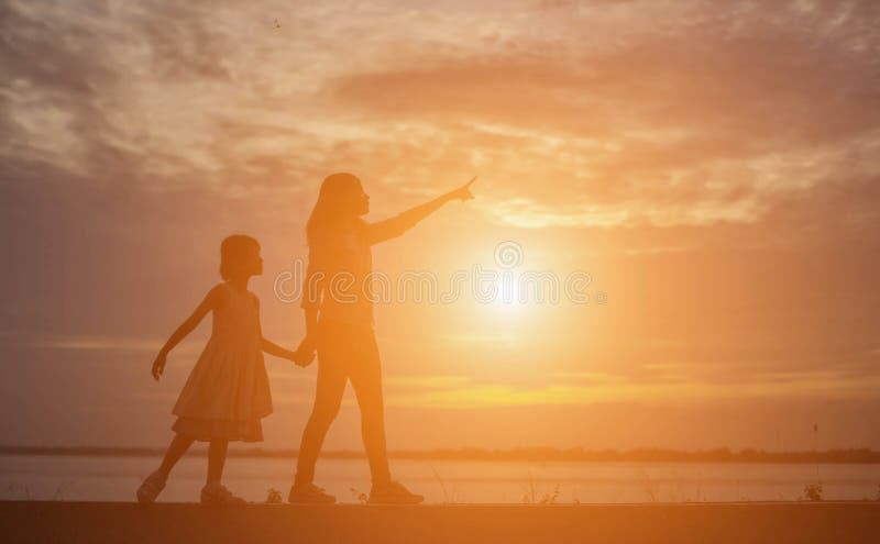 De vrouwen en de kinderen letten op de zonsondergang in de avond royalty-vrije stock fotografie De vrouwen en de kinderen letten op de zonsondergang in de avond royalty-vrije stock fotografie