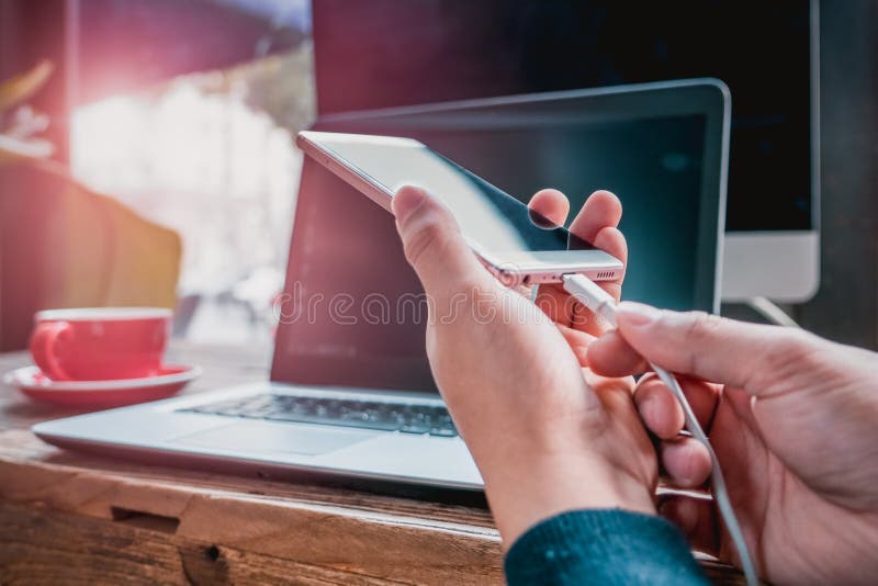 De vrouwenhand houdt de het laden kabel die de slimme mobiele telefoon stoppen, steen en lawaai is de filter van toepassing royalty-vrije stock afbeelding De vrouwenhand houdt de het laden kabel die de slimme mobiele telefoon stoppen, steen en lawaai is de filter van toepassing royalty-vrije stock afbeelding