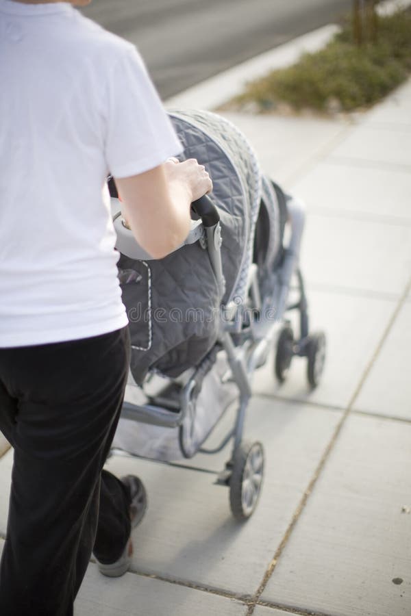 De wandelwagen van de moeder en van de baby stock afbeeldingen De wandelwagen van de moeder en van de baby stock afbeeldingen