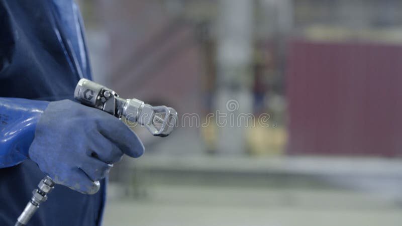 De wapenhand die industrieel groottespuitpistool houden gebruikte voor het industriële schilderen en het met een laag bedekken Ma royalty-vrije stock foto's De wapenhand die industrieel groottespuitpistool houden gebruikte voor het industriële schilderen en het met een laag bedekken Ma royalty-vrije stock foto's