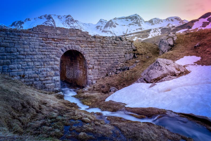 De watervallandschap van de bergstroom en brug bij zonsondergang, de Pyreneeën royalty-vrije stock fotografie De watervallandschap van de bergstroom en brug bij zonsondergang, de Pyreneeën royalty-vrije stock fotografie
