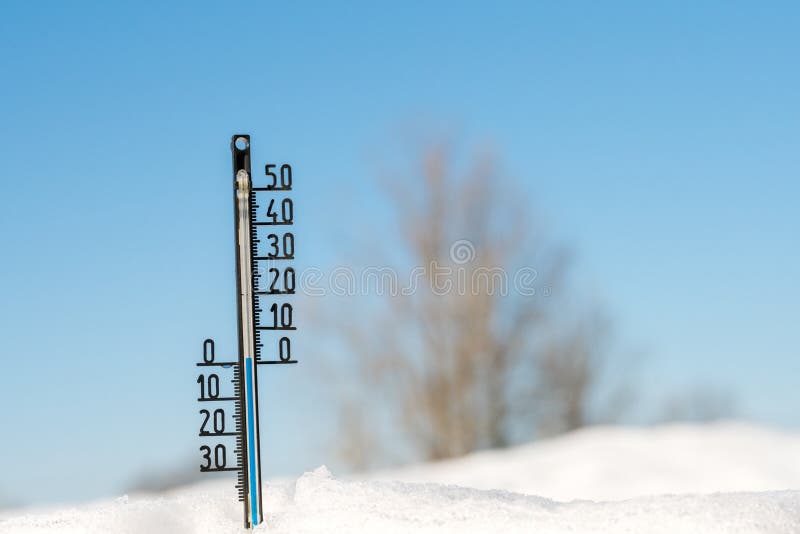 De weervoorspellingsthermometer op sneeuw toont lage temperatuur Blauwe hemel meteorologie