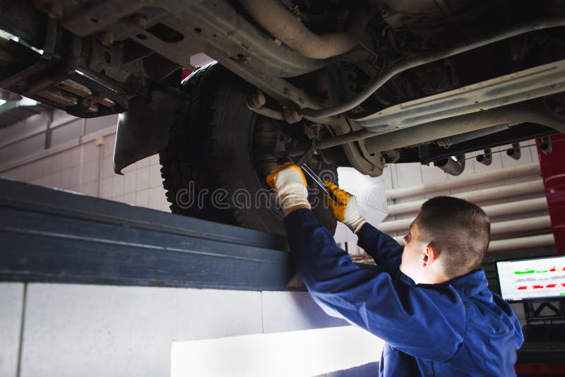 De werktuigkundige krijgt opschortingssysteem bij de autodienst terug stock afbeelding De werktuigkundige krijgt opschortingssysteem bij de autodienst terug stock afbeelding