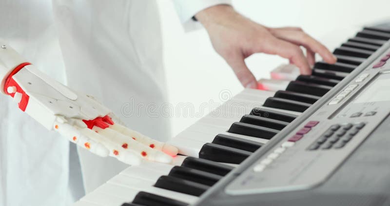 De wetenschapperingenieur proeft robotachtige prothesehand spelend de piano E