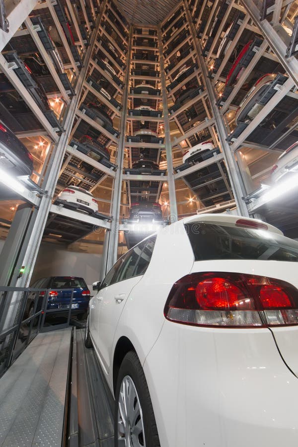 De Witte Auto Op Parkeerterrein Met Het Geautomatiseerde Systeem Van Het Autoparkeren Stock