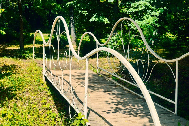 De witte gesmede brug in een tuin royalty-vrije stock foto De witte gesmede brug in een tuin royalty-vrije stock foto
