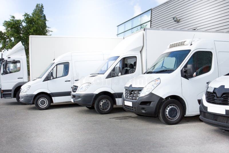 De witte vrachtwagen van leveringsbestelwagens bij het parkeren van vooraan op de ingang een pakhuis bij distributiebestelwagen royalty-vrije stock foto's De witte vrachtwagen van leveringsbestelwagens bij het parkeren van vooraan op de ingang een pakhuis bij distributiebestelwagen royalty-vrije stock foto's