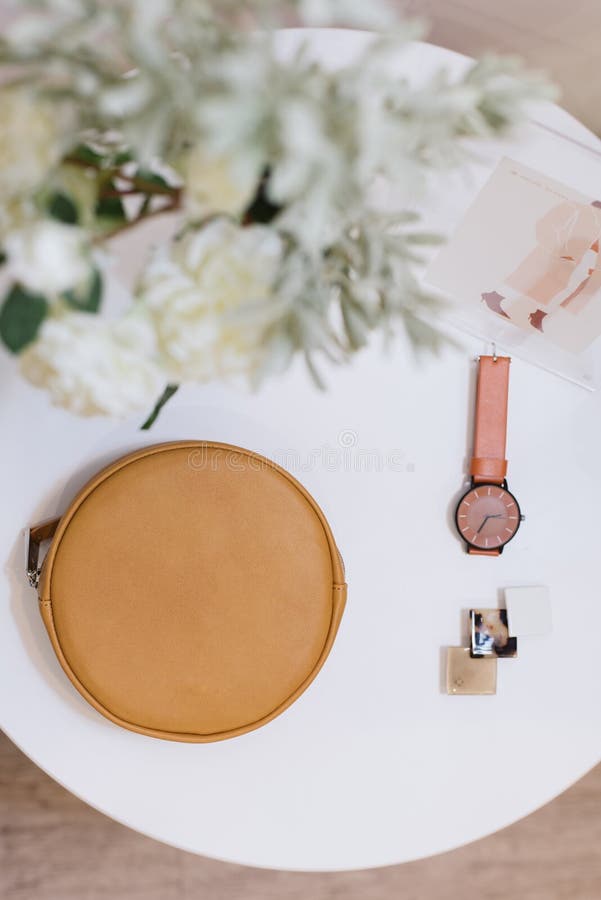 De zak, het horloge en het haarspeldje liggen op een witte lijst royalty-vrije stock fotografie De zak, het horloge en het haarspeldje liggen op een witte lijst royalty-vrije stock fotografie