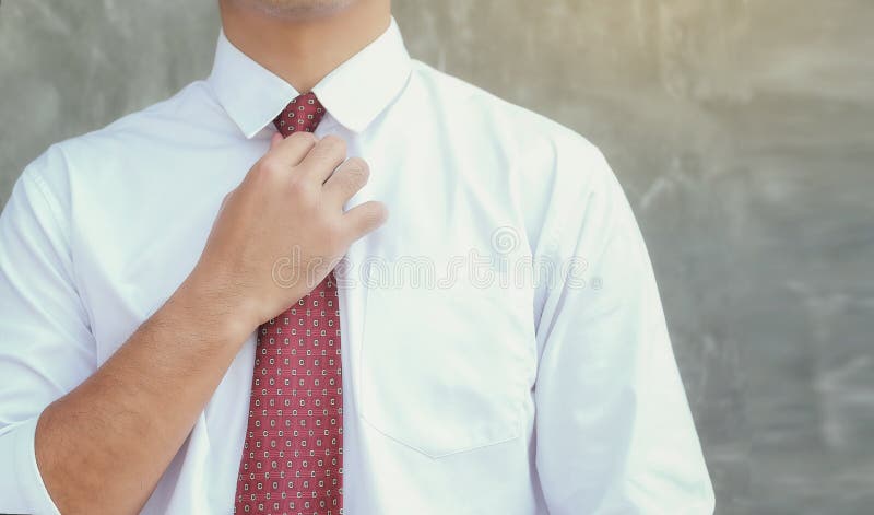 De zakenlieden verfraaien een rode stropdas op de dag van zijn eerste stock foto De zakenlieden verfraaien een rode stropdas op de dag van zijn eerste stock foto
