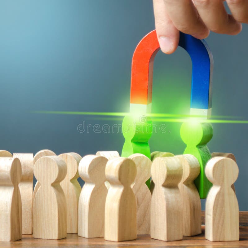 De zakenman met een magneet trekt twee groene cijfers van mensen uit de menigte Vorming van een nieuw commercieel team van kandid stock foto's De zakenman met een magneet trekt twee groene cijfers van mensen uit de menigte Vorming van een nieuw commercieel team van kandid stock foto's