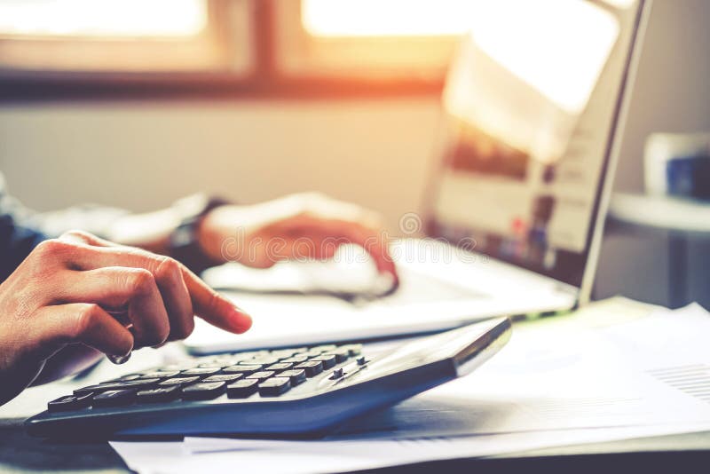 De zakenman` s handen met calculator op het kantoor en de Financiële gegevens kosten Economisch