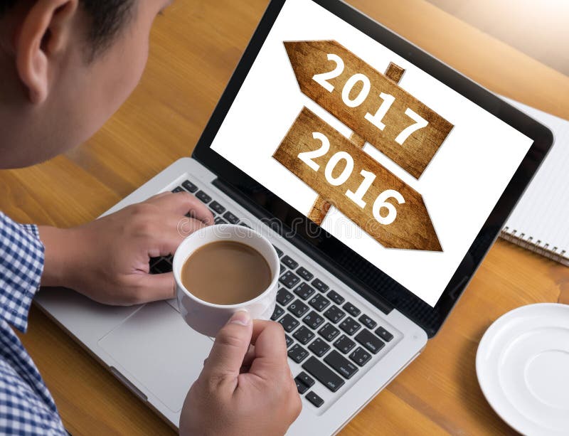 2016 2017 Businessman at work. Close-up top view of man working on laptop while sitting at the wooden desk , coffee