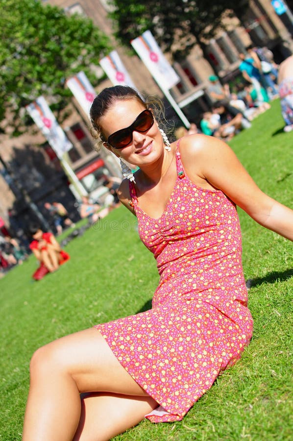 De zitting van de vrouw op gras in park stock afbeeldingen De zitting van de vrouw op gras in park stock afbeeldingen