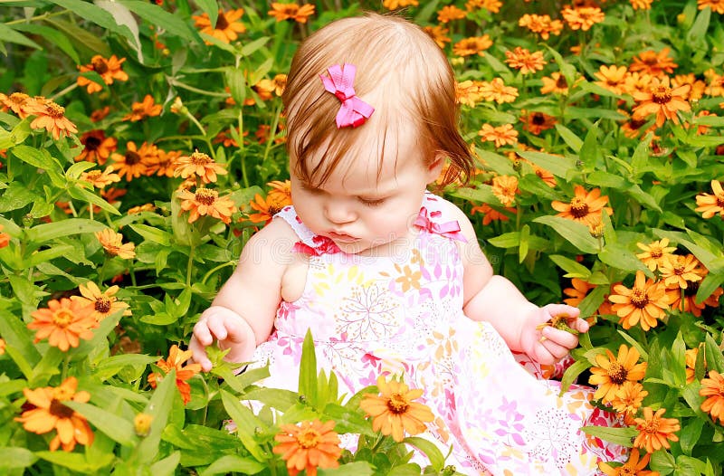 De Zitting van het meisje in Bloemen stock afbeelding De Zitting van het meisje in Bloemen stock afbeelding