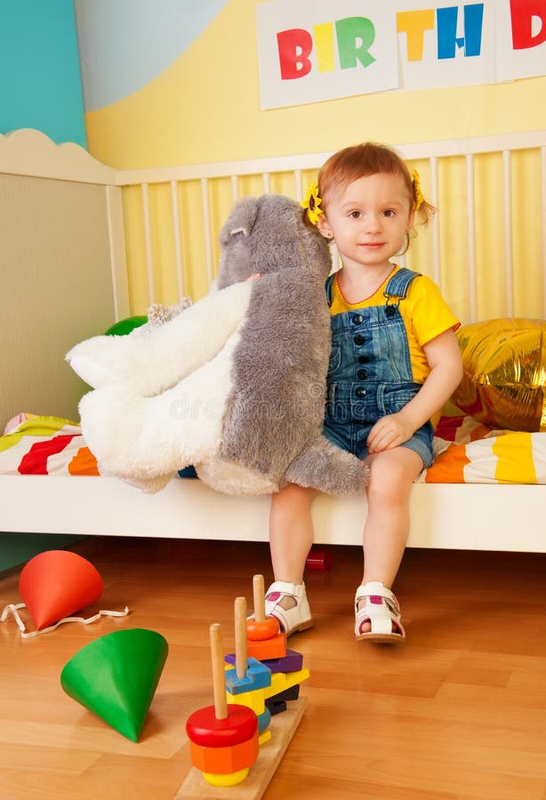De zitting van het meisje in het babybed met jongens royalty-vrije stock afbeelding De zitting van het meisje in het babybed met jongens royalty-vrije stock afbeelding