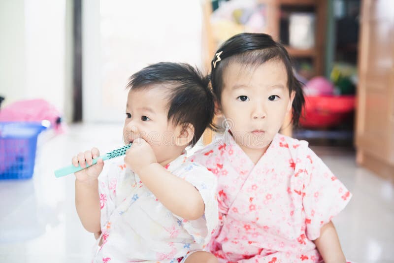 De zoete Aziatische kleine kinderen genieten van thuis samen speel stock foto De zoete Aziatische kleine kinderen genieten van thuis samen speel stock foto