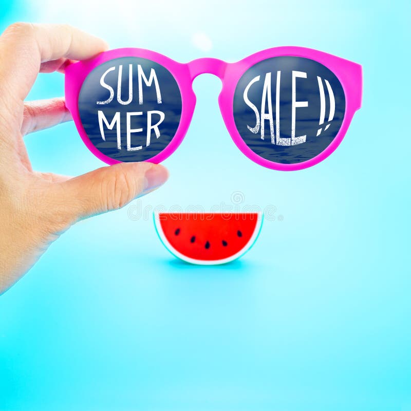 De zomer roze glazen van de handholding met de zomerverkoop! woord en wate royalty-vrije stock afbeelding De zomer roze glazen van de handholding met de zomerverkoop! woord en wate royalty-vrije stock afbeelding