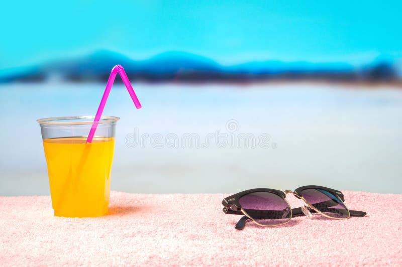 De zomerachtergrond met gele cocktail en zonnebril op handdoek op het strand Mooie vage paradijs oceaanmening stock foto De zomerachtergrond met gele cocktail en zonnebril op handdoek op het strand Mooie vage paradijs oceaanmening stock foto