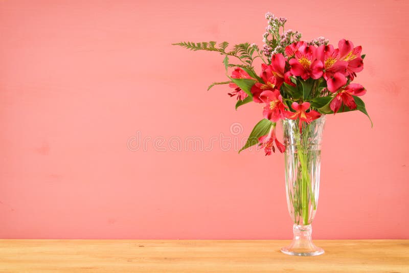 de zomerboeket van rode en roze bloemen in de vaas over houten lijst en pastelkleurachtergrond stock fotografie de zomerboeket van rode en roze bloemen in de vaas over houten lijst en pastelkleurachtergrond stock fotografie