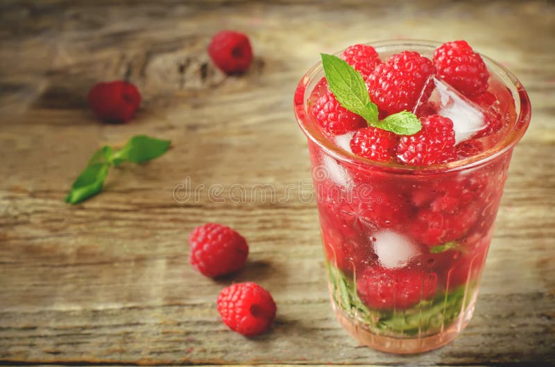 De zomersap met verse frambozenmunt en ijs in een glas royalty-vrije stock foto De zomersap met verse frambozenmunt en ijs in een glas royalty-vrije stock foto