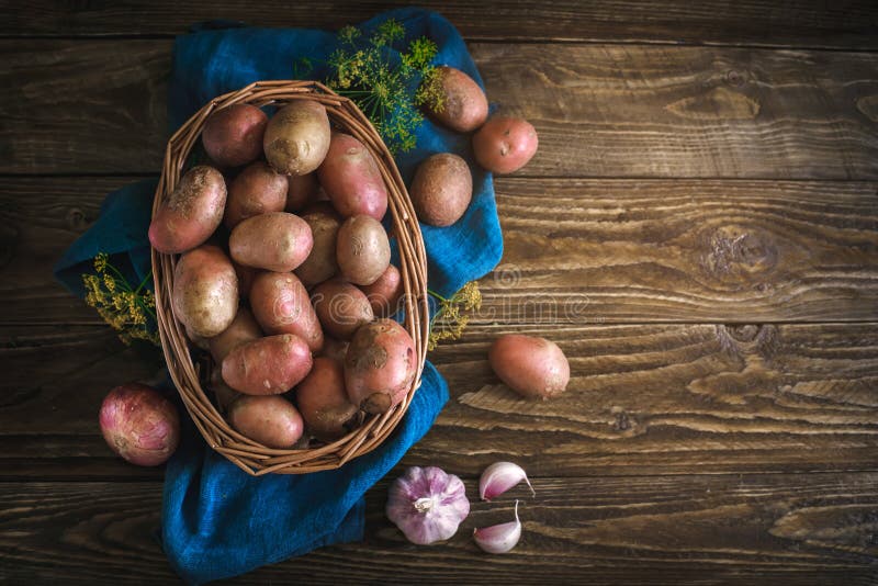 De zomerstilleven van rijpe aardappels op een houten lijst stock foto De zomerstilleven van rijpe aardappels op een houten lijst stock foto