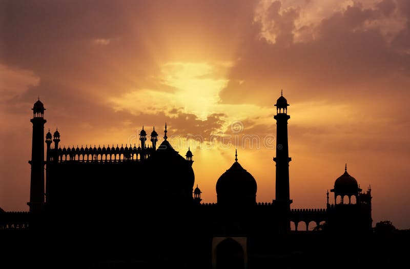 Silhouette of great mosque of Old Delhi, India, with light rays of a divine golden light in the background. Silhouette of great mosque of Old Delhi, India, with light rays of a divine golden light in the background.