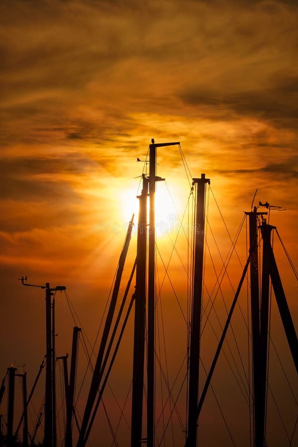 De zonsonderganglicht van Nice in een haven met zeilbotenmasten stock afbeeldingen De zonsonderganglicht van Nice in een haven met zeilbotenmasten stock afbeeldingen