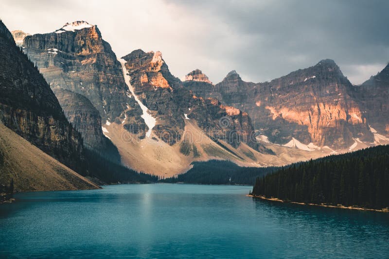 De zonsopgang met turkooise wateren van het Morenemeer met zonde stak rotsachtige bergen binnen in het Nationale Park van Banff v stock fotografie De zonsopgang met turkooise wateren van het Morenemeer met zonde stak rotsachtige bergen binnen in het Nationale Park van Banff v stock fotografie